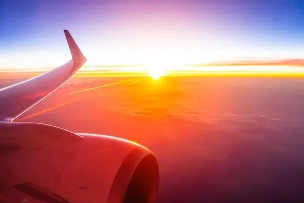 An airliner wing above the clouds at sunrise