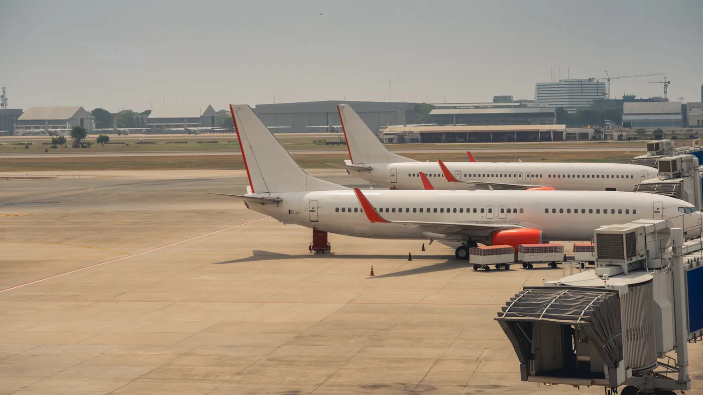 Passenger jets parked on an airport apron beside the terminal