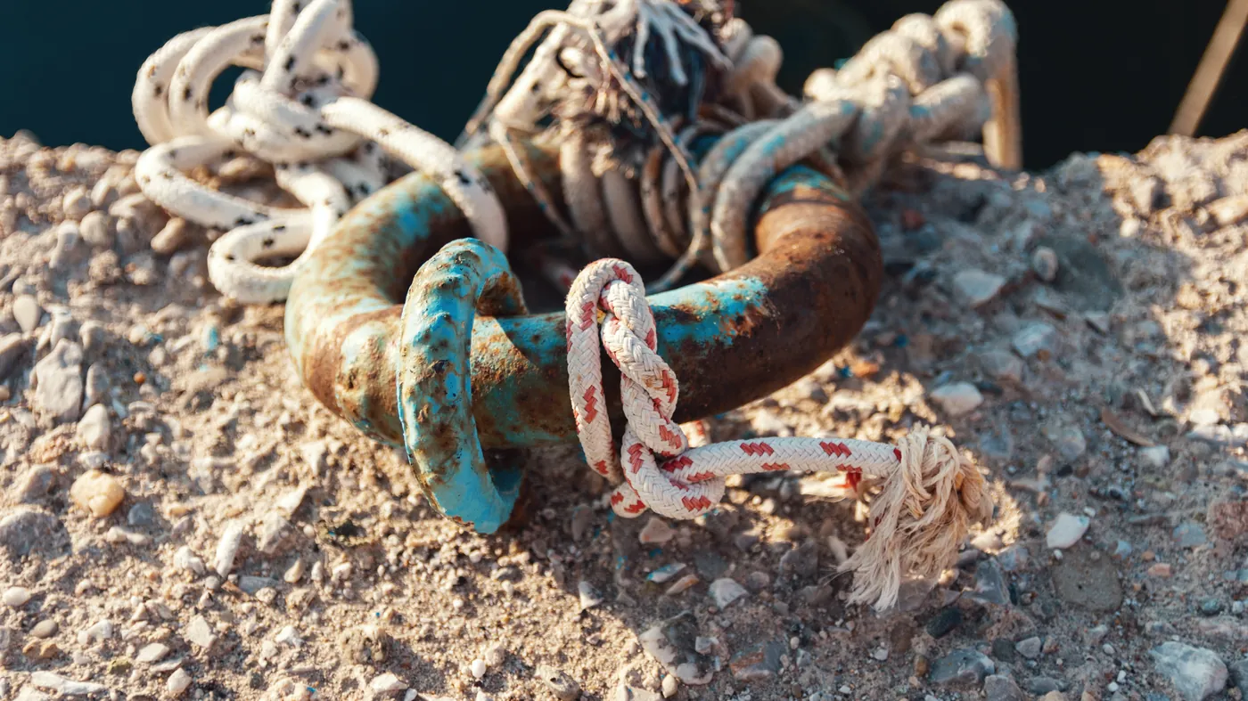 Ropes tied to a mooring ring on a concrete pier