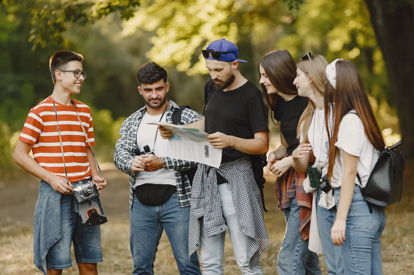 Group of smiling walkers in a forest, one holding a map