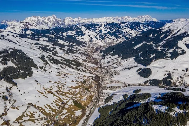 Vista aérea de un paisaje montañoso nevado bajo el sol