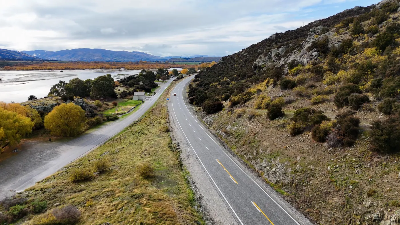 A winding highway beside a lake and mountains near Queenstown