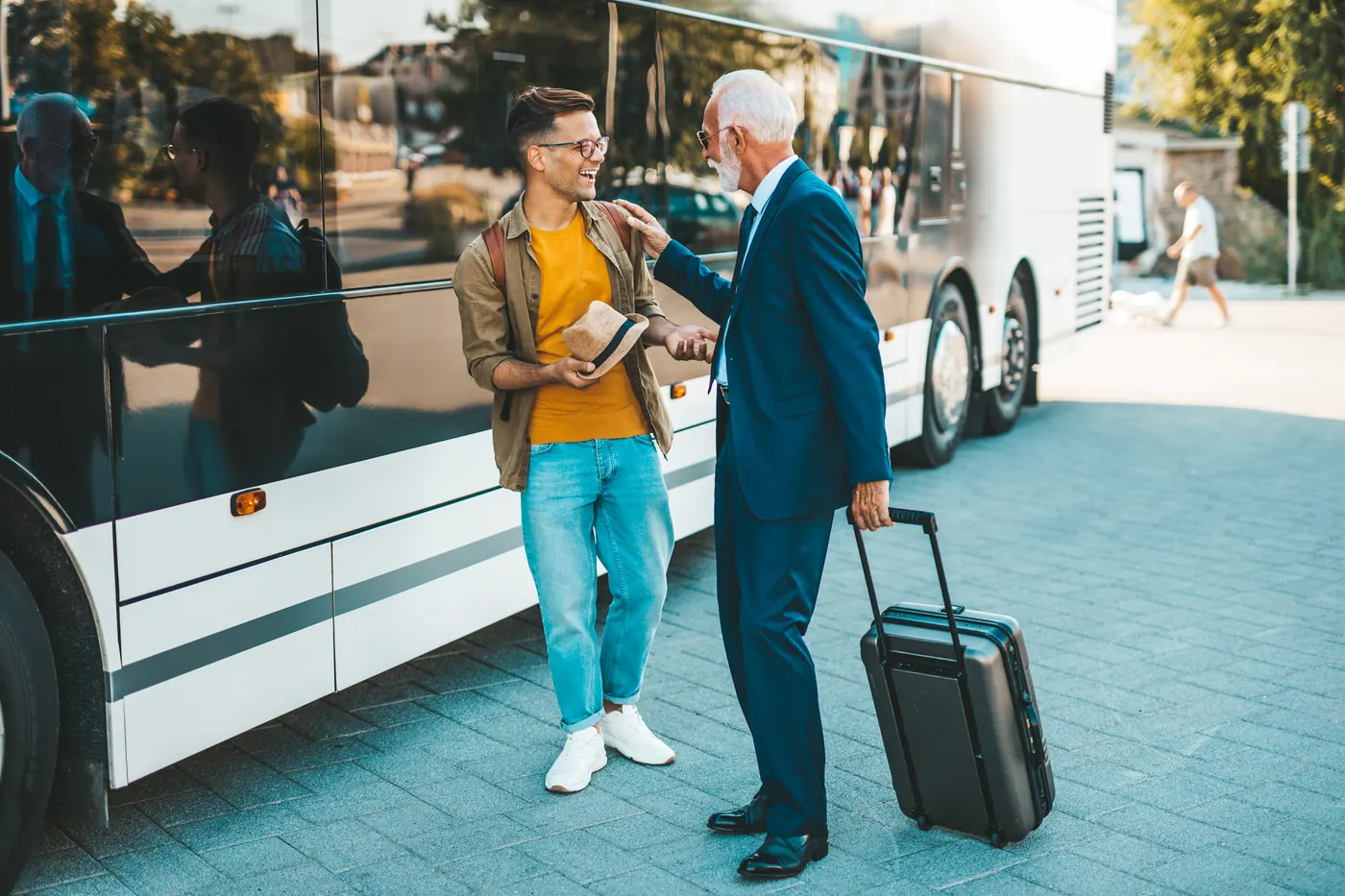 A coach driver taking a passenger's suitcase