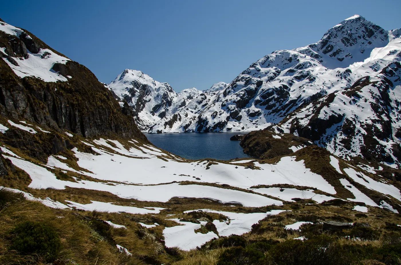 Schneebedeckte Berge über einem See, gesehen vom Routeburn Track in Neuseeland