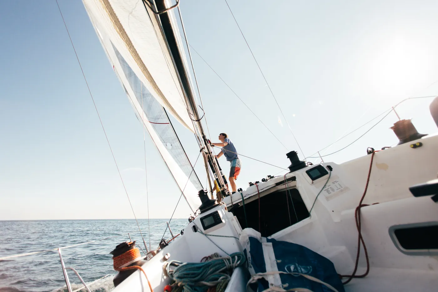 Crew working on the deck of a racing yacht under full sail