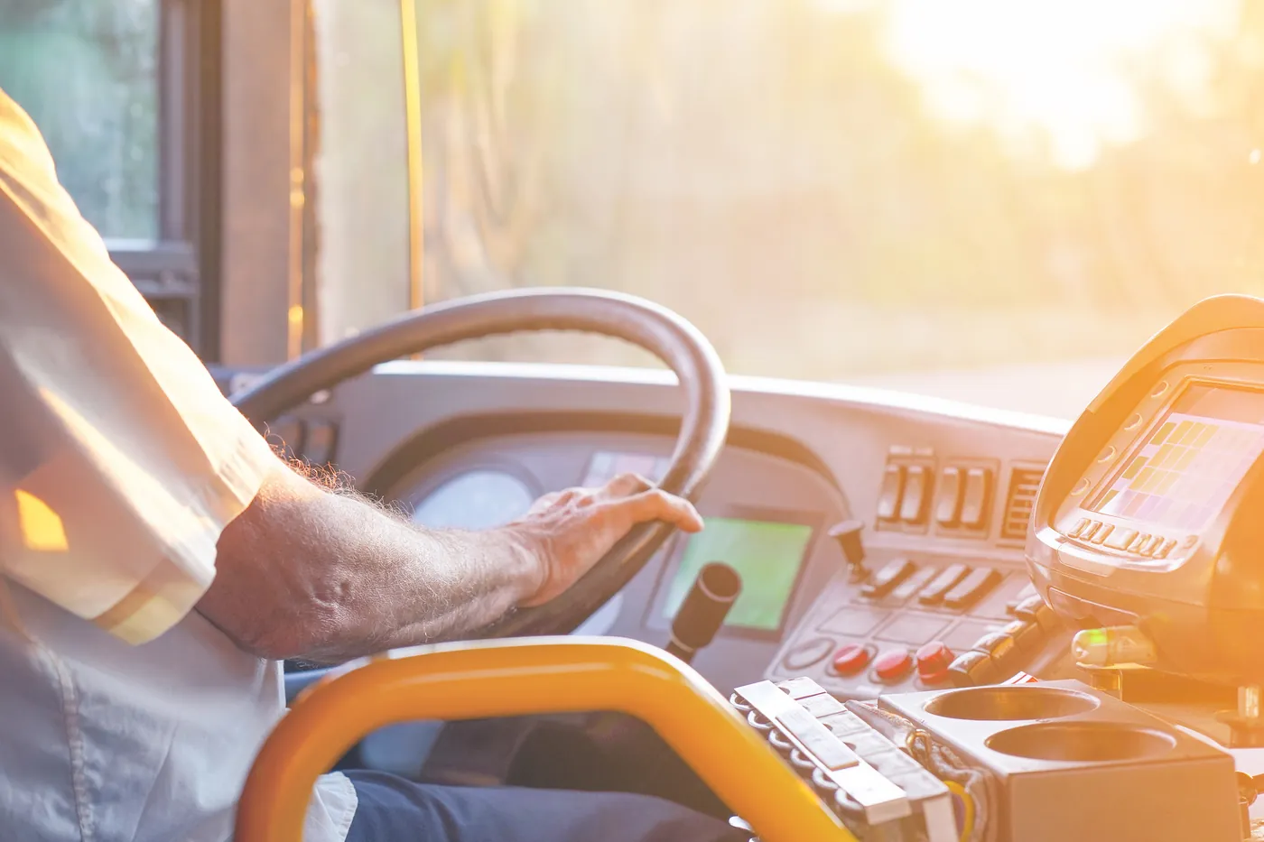 A driver's hands on the steering wheel of a coach