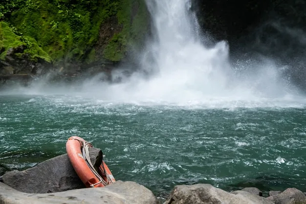 A waterfall and lake framed by trees, with a lifesaving ring hanging from a rock