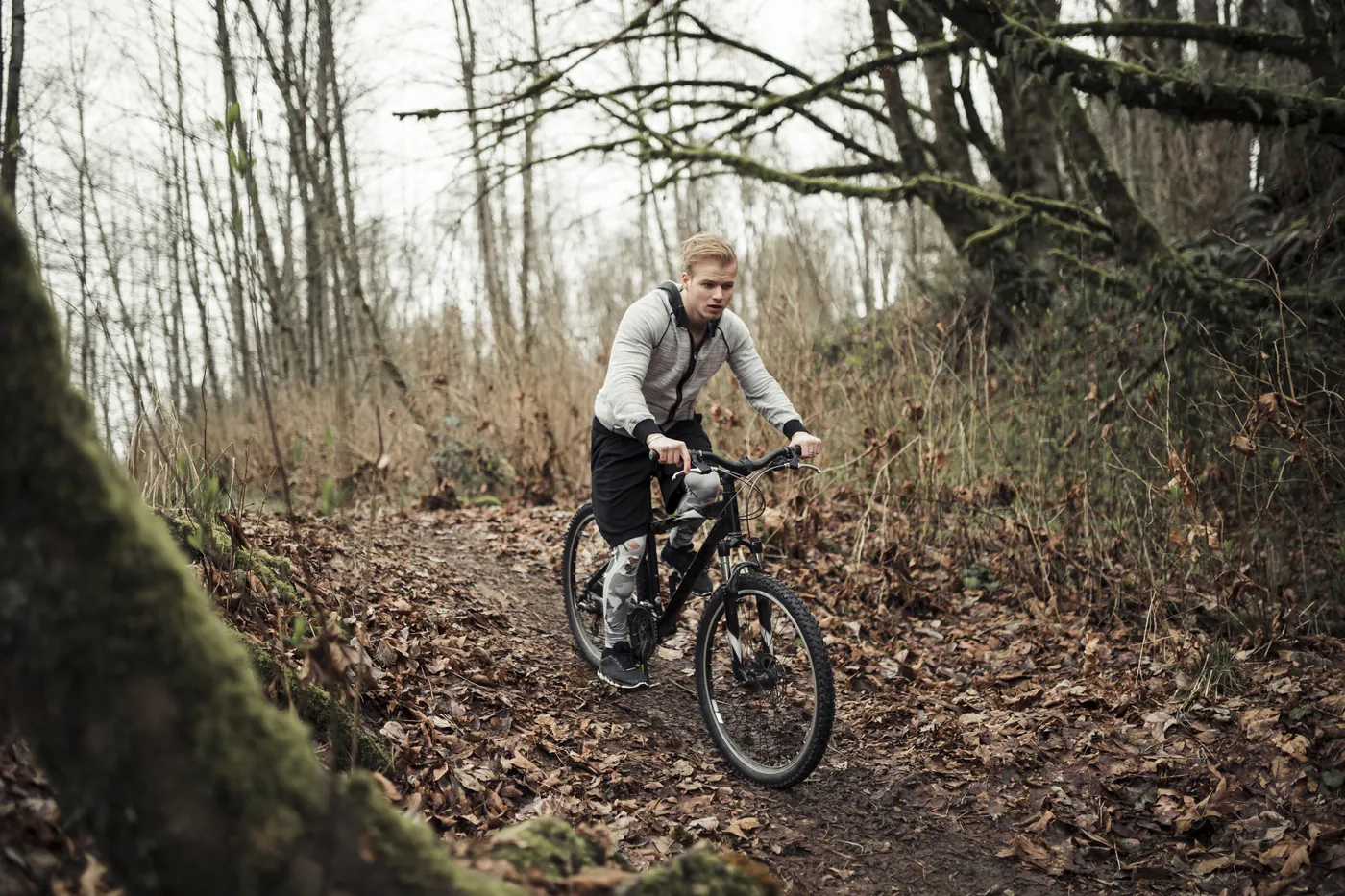 Ein Mountainbiker auf einem laubbedeckten Waldweg