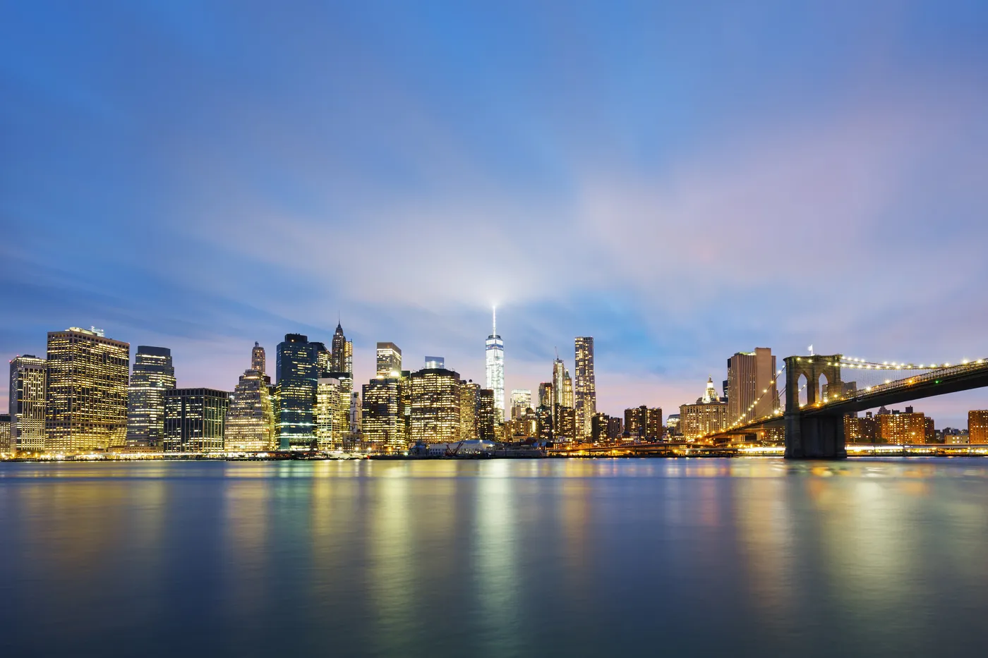 The New York skyline lit up at dusk across the river