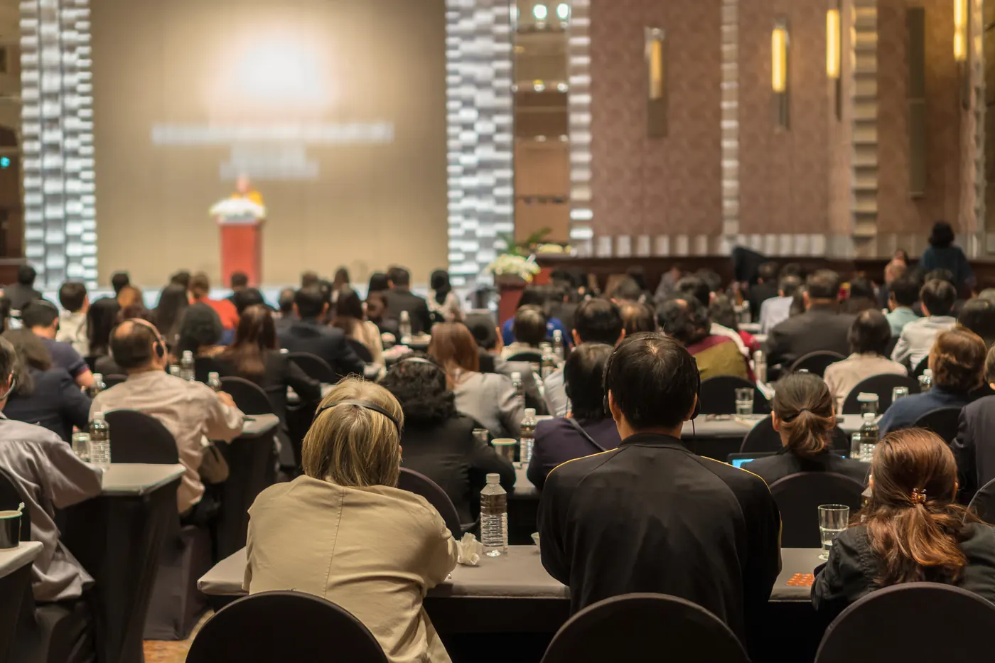 Delegates seated at round tables in a conference ballroom